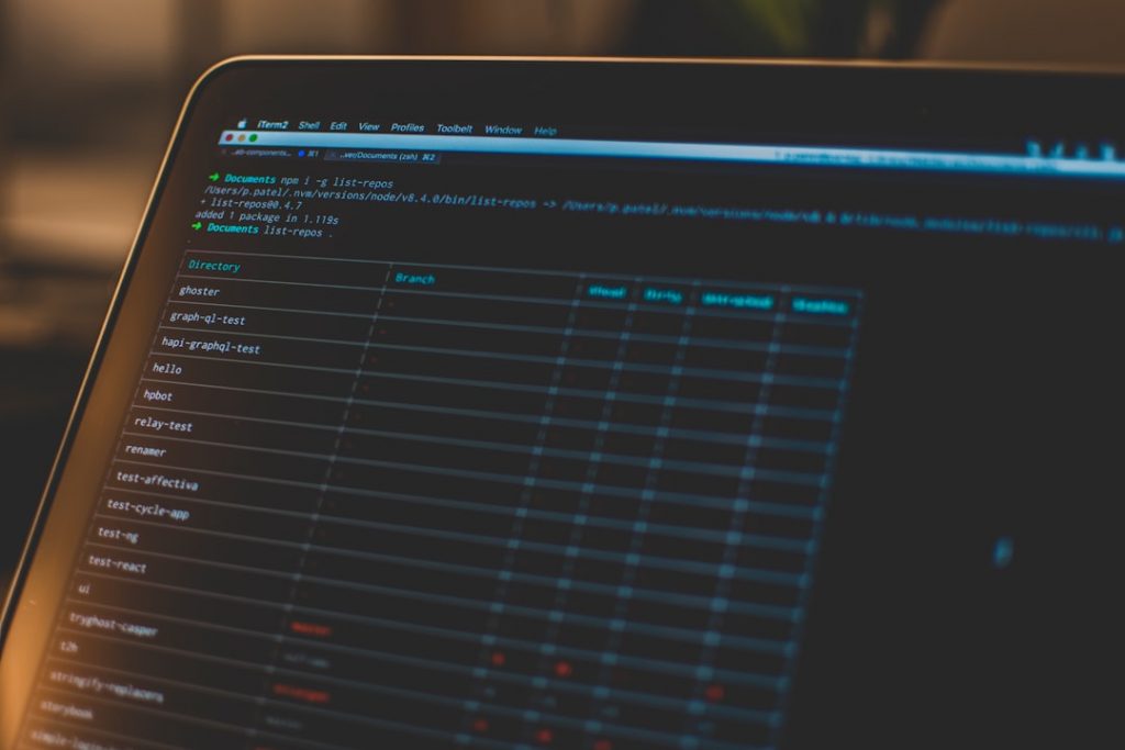 A close-up of a laptop screen displaying a dark-themed code editor with a table of directories, branches, and files, suggesting software development or version control work.